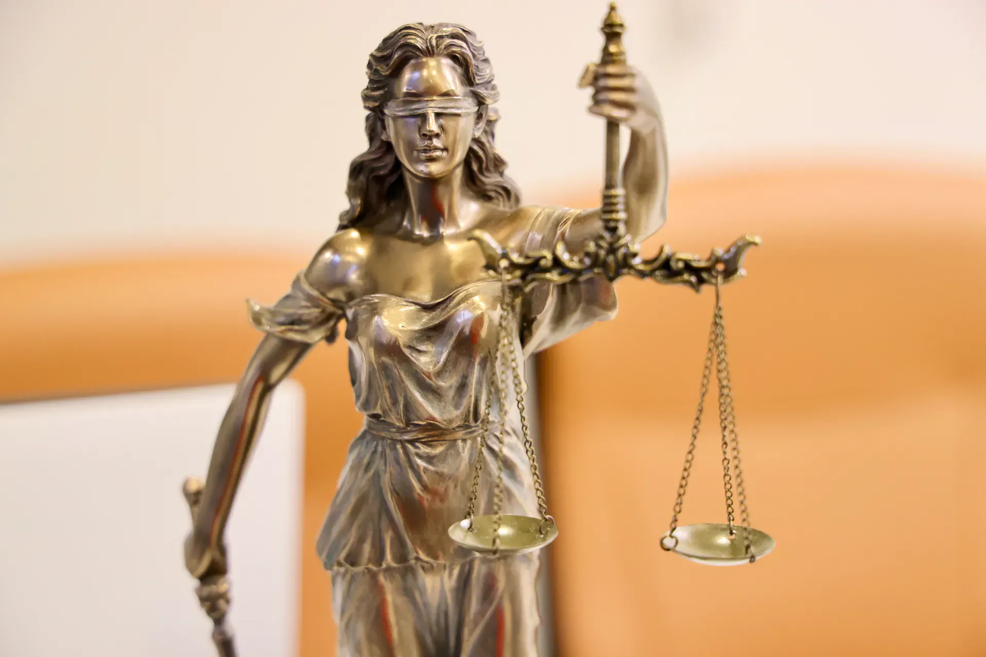 A bronze figure of Justice holding balanced scales